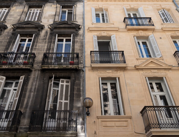 Two neighbouring town houses, one has been cleaned and the other dirty