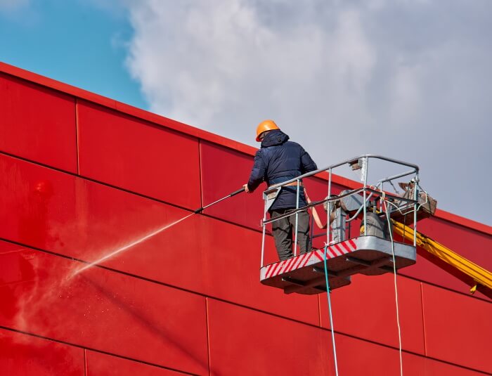 Jet washing cladding on the side of a building