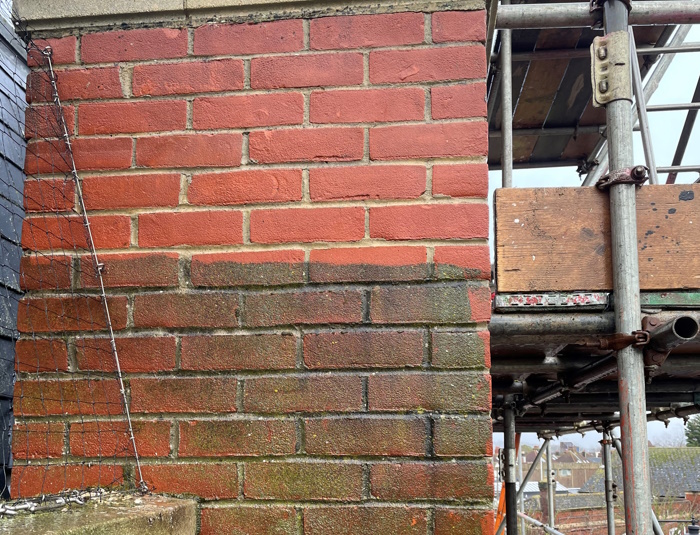 Before and after picture of jet washing a brick wall